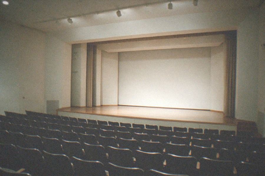 Display cases with gold records and stage costumes under spotlights in a dim gallery