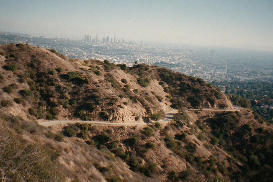 Griffith Observatory seen from a park trail with the city skyline in the distance