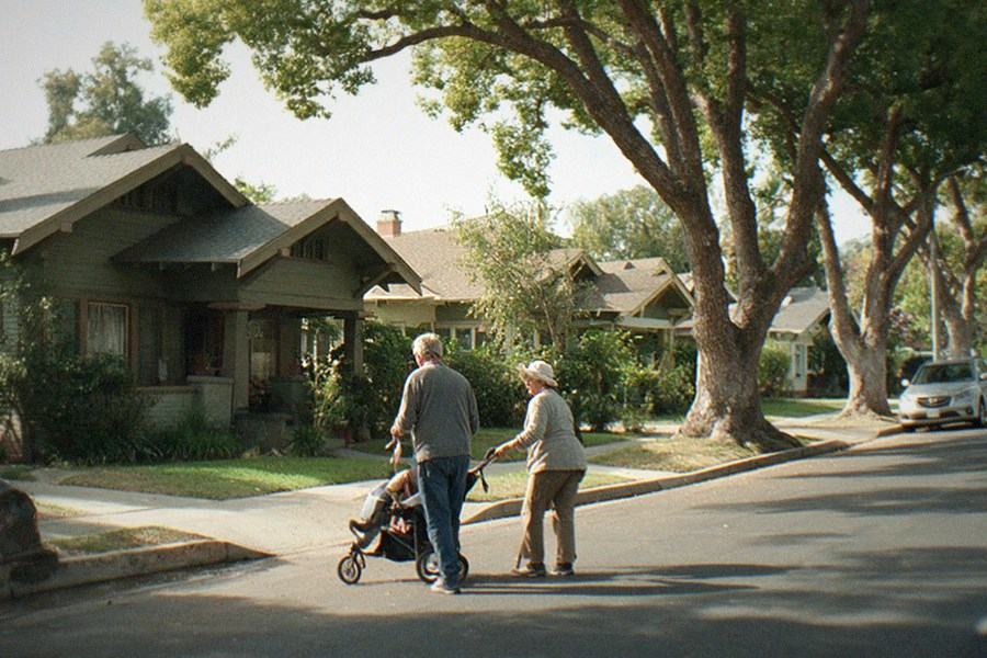 A quiet residential street lined with apartment buildings and parked cars near a museum district