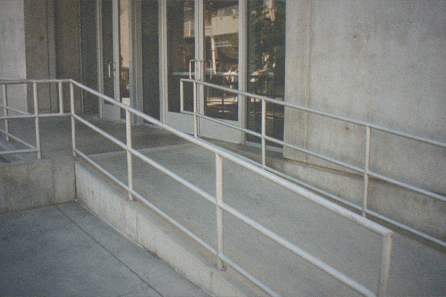 A museum entrance with doors shut and an empty plaza in morning light