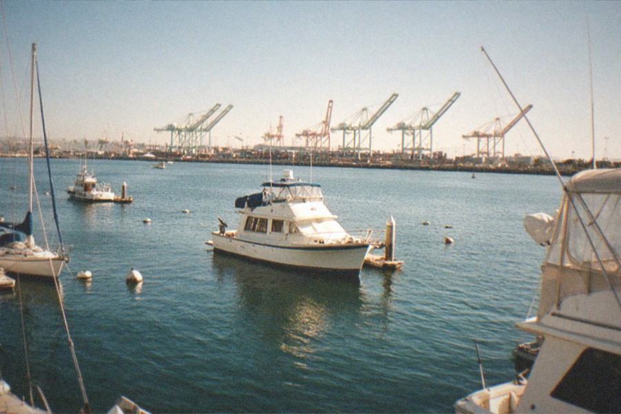 A large gray battleship moored at a waterfront dock with masts and gun turrets visible