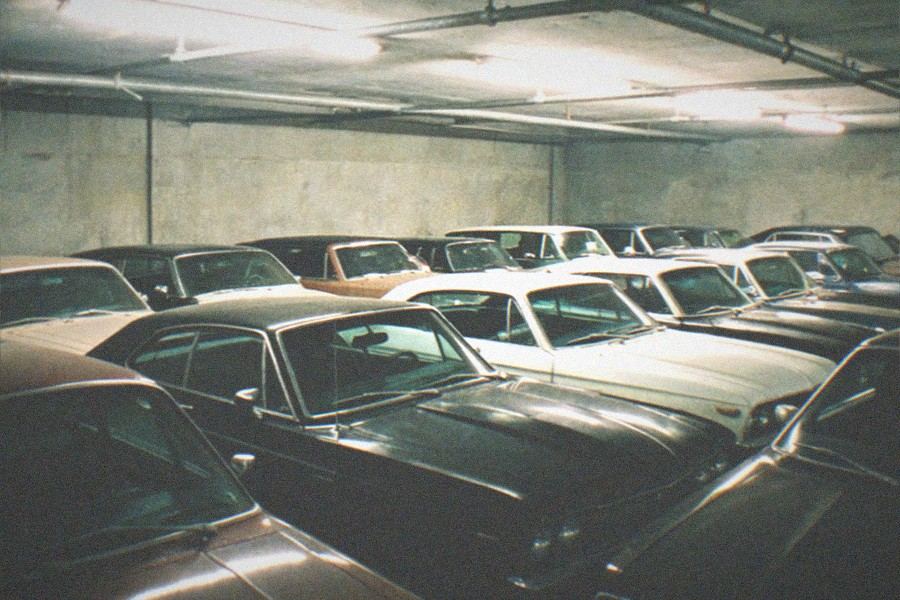 A row of classic and custom cars displayed in a gallery on the Petersen Automotive Museum's exhibit floor